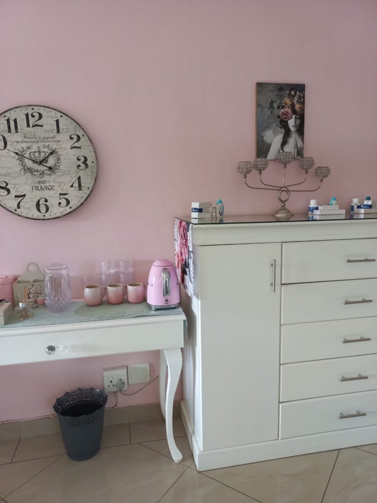 Main bedroom with pink wall and Smeg kettle while searching for the perfect lamp