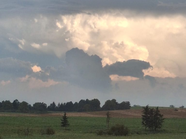 Dramatic clouds over a rural landscape with green fields