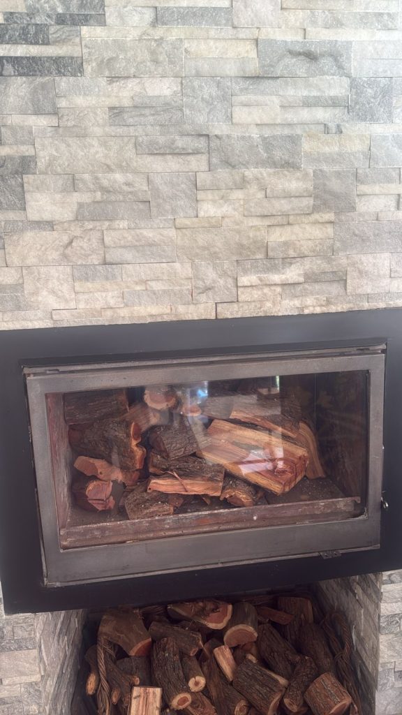 Close-up of existing fireplace set into the stone-clad wall