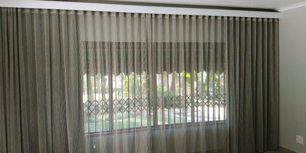 Elegant full length curtains with evenly spaced pleats framing large windows